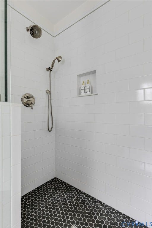 4015 Mount Vernon Street, Bellevue, Richmond, VA 23227 Shower featuring white subway tile walls, black hexagonal floor tile, a built-in recessed niche, and a brushed nickel showerhead with a handheld sprayer