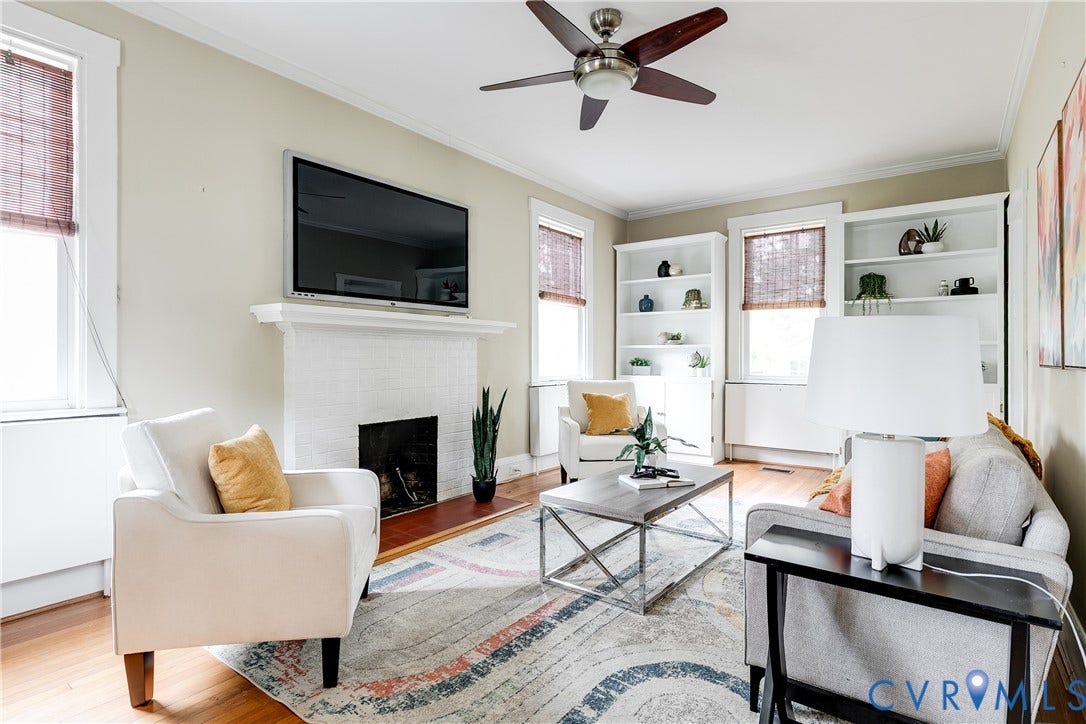 4015 Mount Vernon Street, Bellevue, Richmond, VA 23227 Hardwood flooring throughout, white painted brick fireplace with mantel, built-in shelving, ceiling fan with light fixture, and window treatments