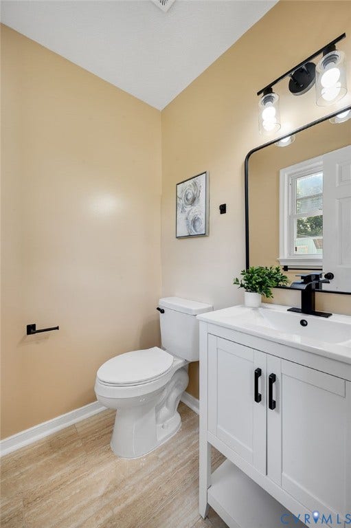 4411 Samara Drive, Henrico, VA 23231 White vanity with matte black hardware, integrated rectangular sink, wall-mounted matte black faucet, and a large framed mirror
