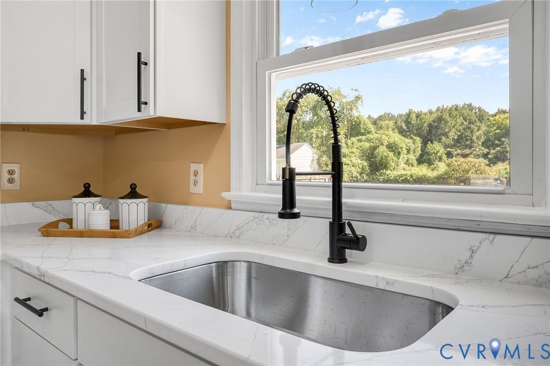 4411 Samara Drive, Henrico, VA 23231 Undermount stainless steel sink with a matte black pull-down faucet, framed by white cabinetry with black hardware, and white countertops with veining