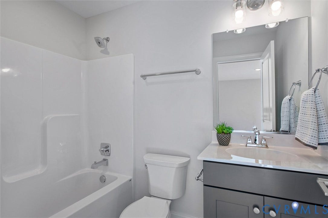 2871 Old Pump Road, The Preserve At John Rolfe, Henrico, VA 23233 White tub/shower combination, polished chrome fixtures, rectangular vanity mirror, gray vanity cabinet, and white countertop