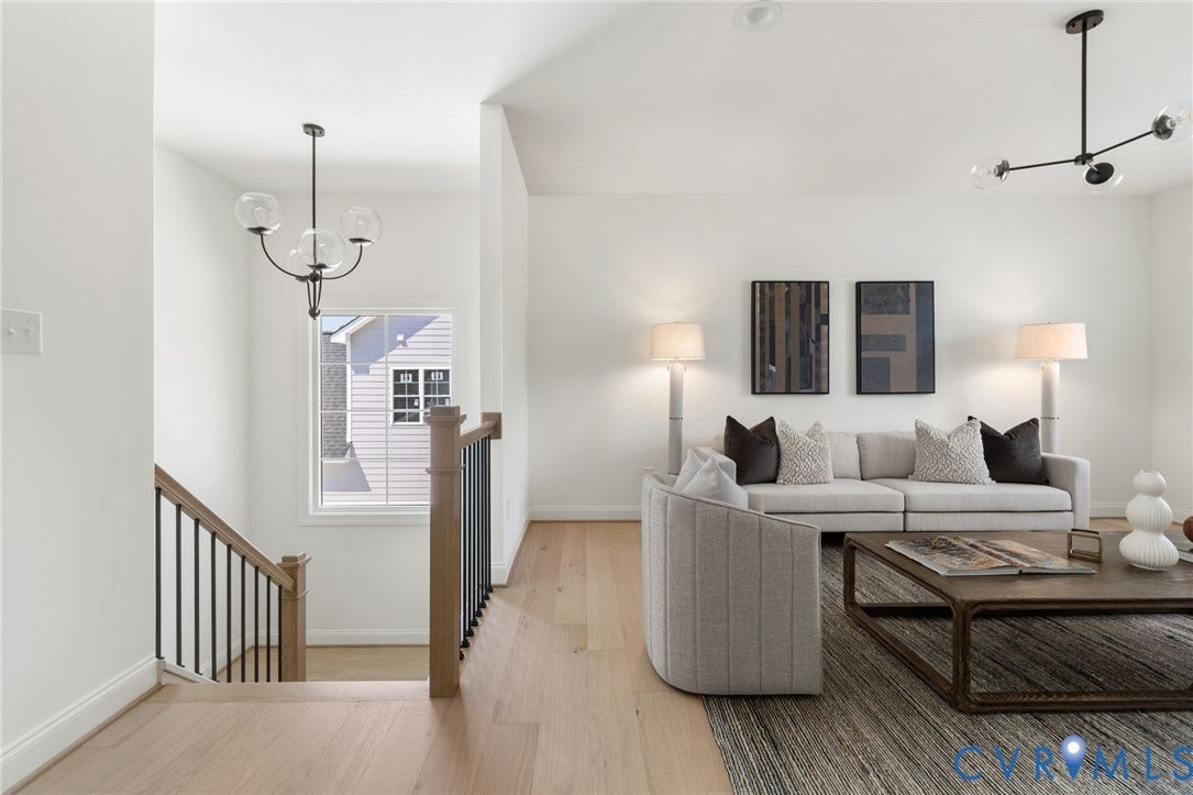 2871 Old Pump Road, The Preserve At John Rolfe, Henrico, VA 23233 Hardwood flooring throughout, modern black and clear glass chandeliers, white walls, and a staircase with wood handrails and black balusters