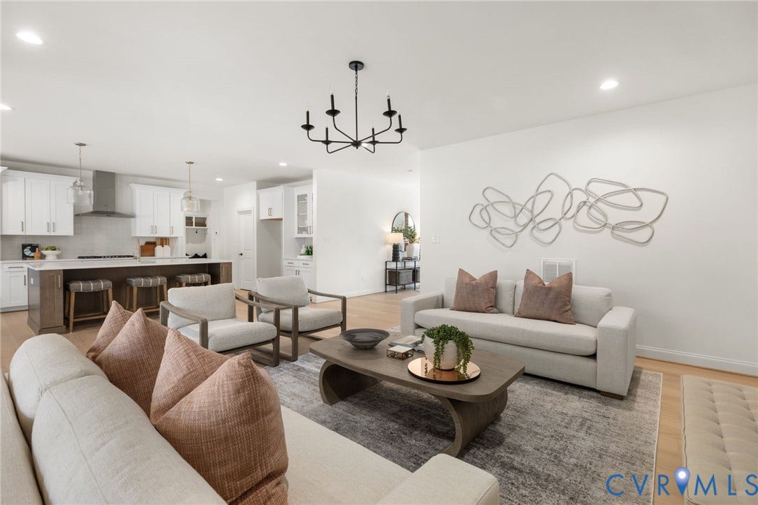 2871 Old Pump Road, The Preserve At John Rolfe, Henrico, VA 23233 Open-concept living space featuring wood-finish flooring, a kitchen island with seating, white cabinetry, and a black chandelier