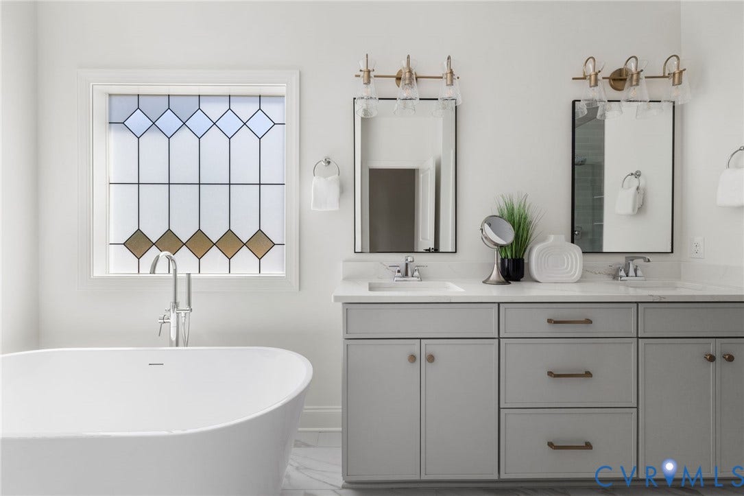 2871 Old Pump Road, The Preserve At John Rolfe, Henrico, VA 23233 Freestanding soaking tub with chrome-finish faucet, decorative privacy window, dual vanity with undermount sinks, and wall-mounted light fixtures