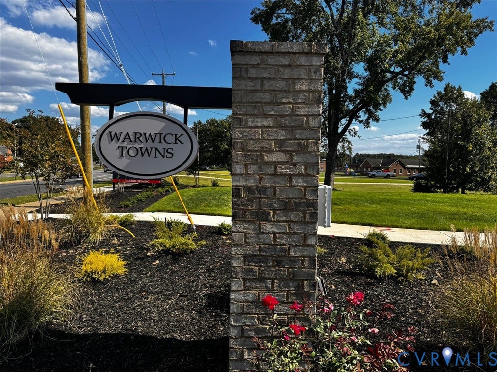 Brick entrance column with a "Warwick Towns" sign