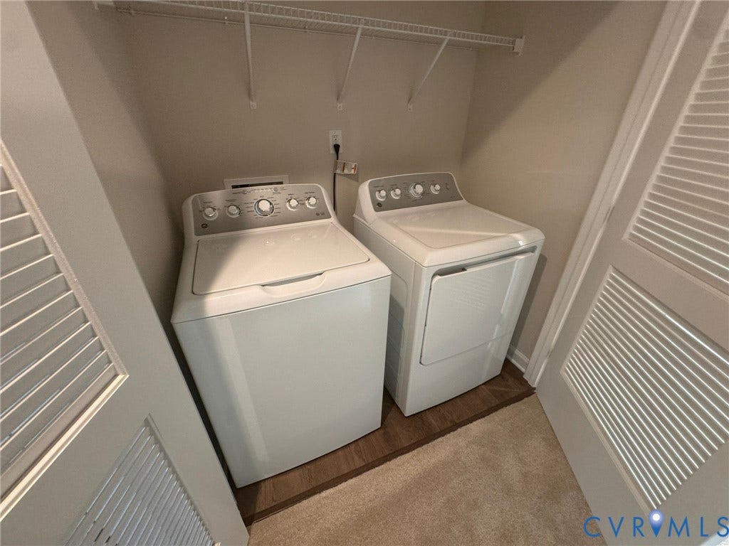 Dedicated laundry area with built-in shelving, wood-finish flooring, and louvered bifold doors