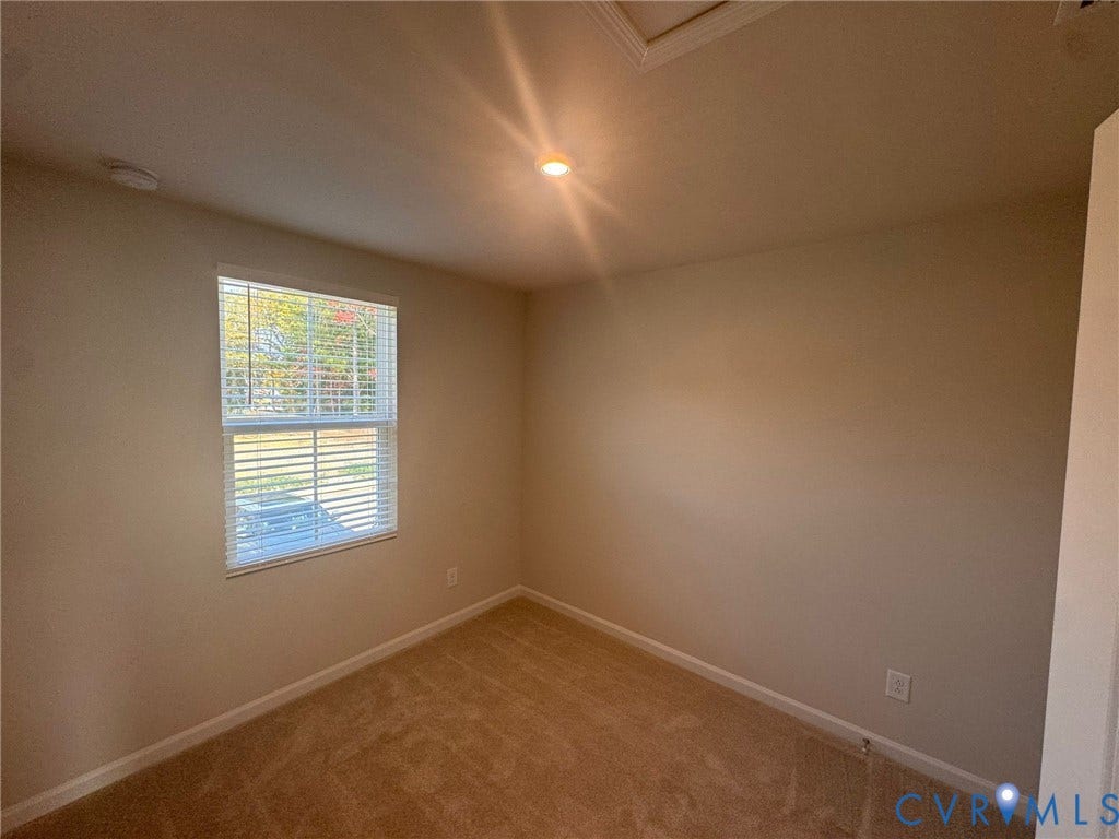 Recessed lighting, neutral wall paint, and textured carpeting