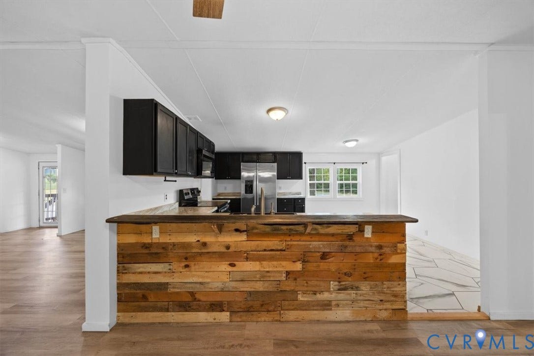 274 Frenchs Store Road, Cumberland, VA 23040 Kitchen featuring a wood-plank breakfast bar, dark-finish cabinetry, stainless steel appliances, and wood-finish flooring