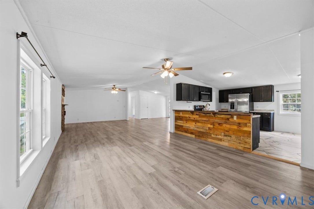 274 Frenchs Store Road, Cumberland, VA 23040 Open-concept interior featuring wood-finish flooring, a kitchen island with reclaimed wood cladding, dark cabinetry, stainless steel appliances, and dual ceiling fans