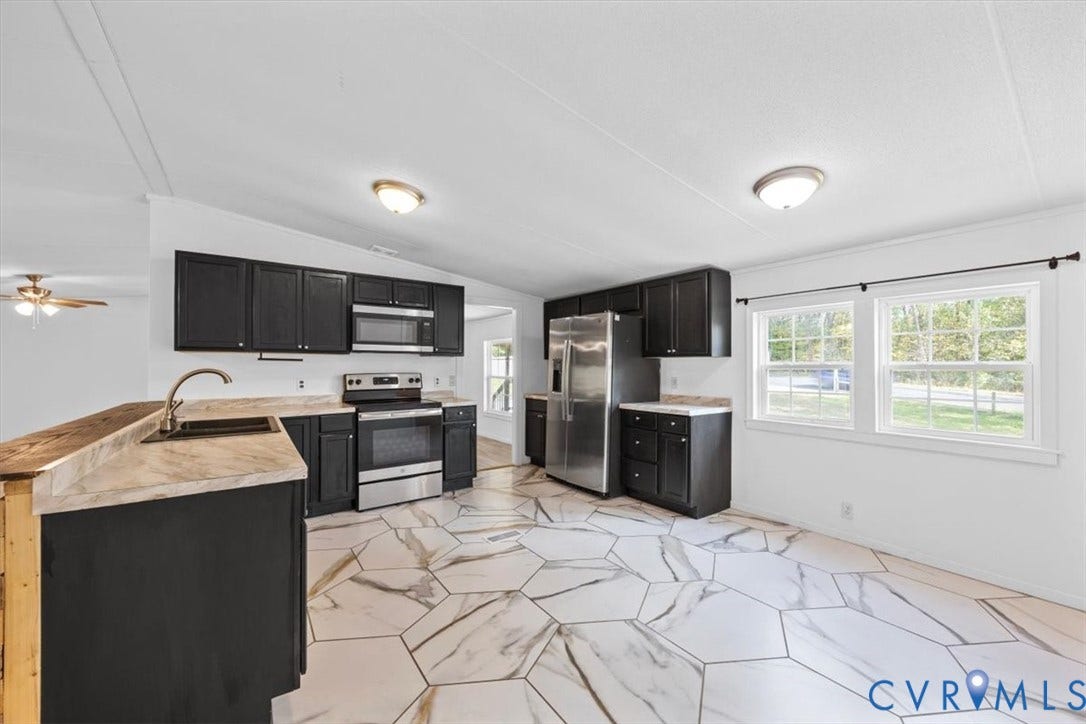 274 Frenchs Store Road, Cumberland, VA 23040 Kitchen featuring dark cabinetry, stainless steel appliances, neutral-toned countertops, and geometric-patterned flooring