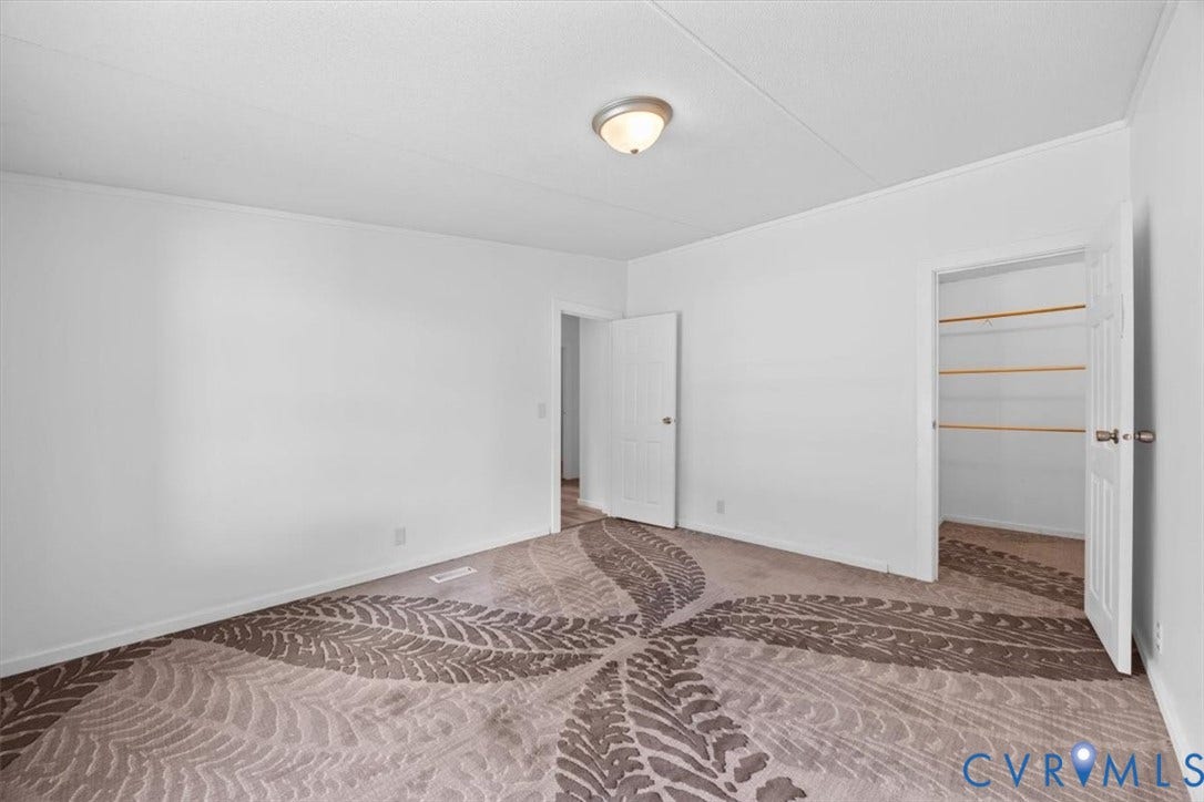274 Frenchs Store Road, Cumberland, VA 23040 Interior space featuring neutral wall tones, patterned carpeting, flush-mount ceiling lighting, and a closet with built-in shelving