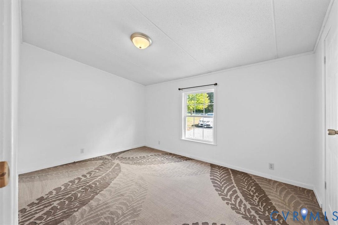274 Frenchs Store Road, Cumberland, VA 23040 Neutral interior space featuring patterned wall-to-wall carpeting, white walls, a flush-mount ceiling light fixture, and a single-hung window with a dark hardware rod