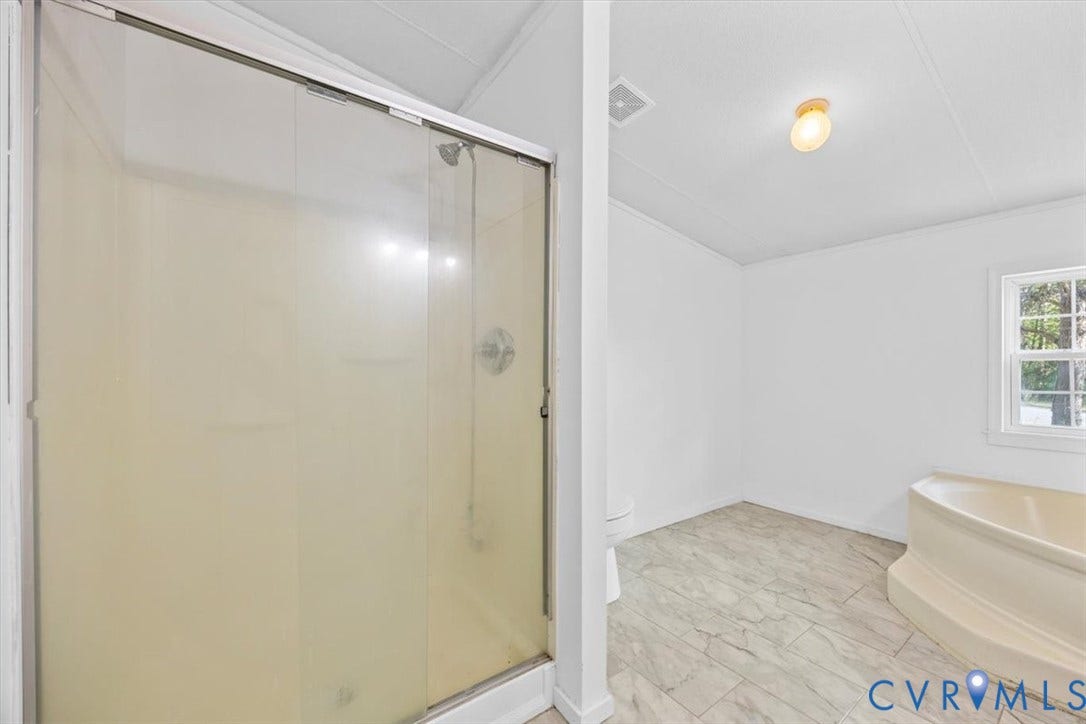 274 Frenchs Store Road, Cumberland, VA 23040 Bathroom featuring a glass-enclosed shower, a soaking tub, stone-finish tile flooring, and a single-pane window