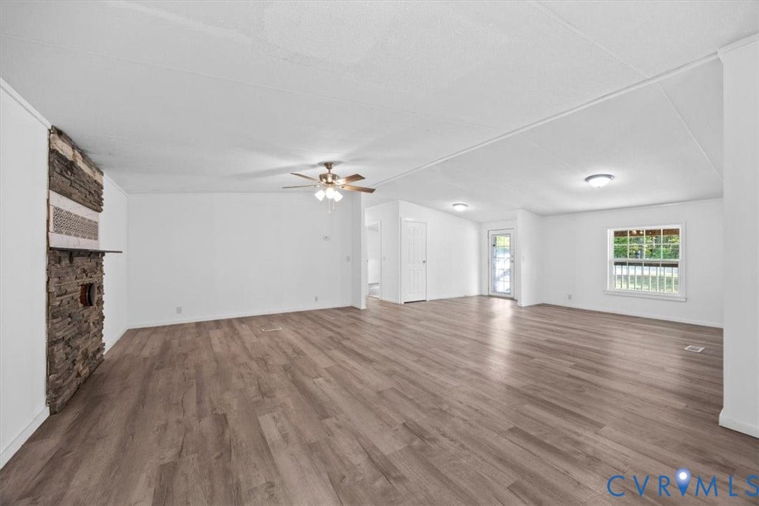 274 Frenchs Store Road, Cumberland, VA 23040 Spacious interior featuring wood-finish flooring, a floor-to-ceiling stone-accented hearth, ceiling fan, and large windows