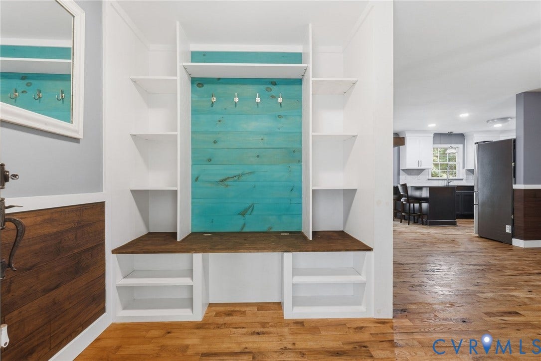 4350 Steger Creek Drive, Powhatan, VA 23139 Built-in storage with a wood-finish bench and shelving, accented by a teal wood-panel backboard with hooks