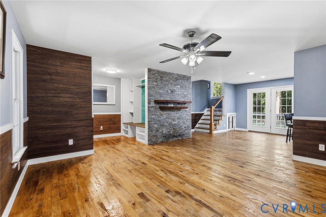 4350 Steger Creek Drive, Powhatan, VA 23139 Hardwood flooring, wood-panel accent walls, built-in shelving, stone-clad fireplace feature, and double French doors