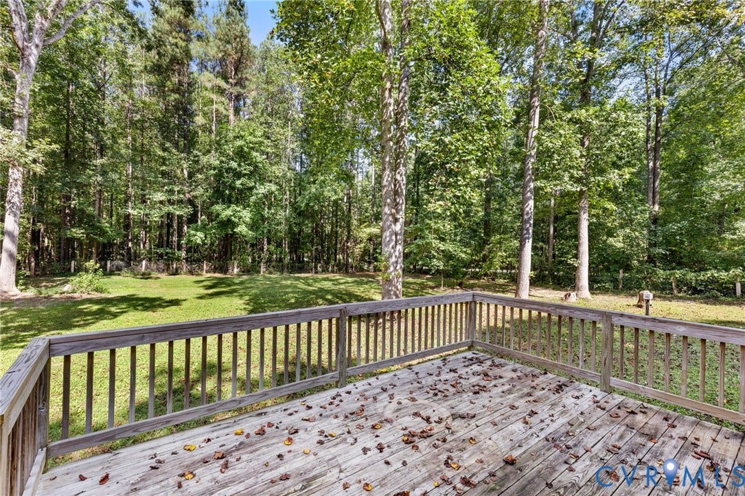 4350 Steger Creek Drive, Powhatan, VA 23139 Expansive wood deck with wood railing overlooking a grassy yard and mature trees