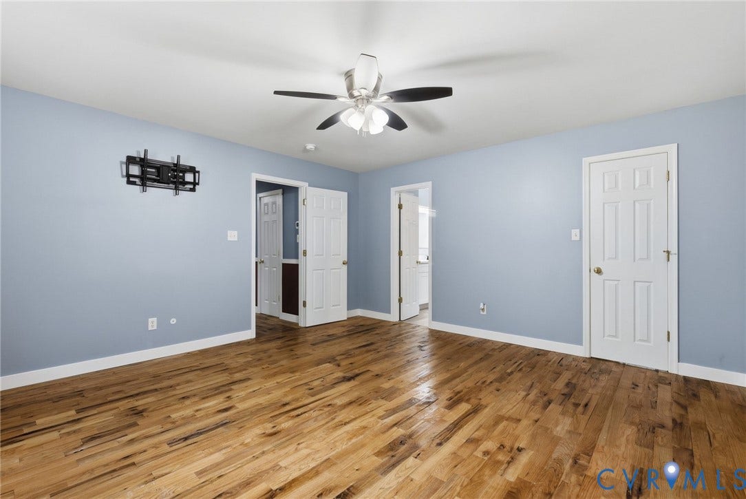 4350 Steger Creek Drive, Powhatan, VA 23139 Hardwood flooring, light blue wall color, white trim, ceiling fan with light fixture, and paneled interior doors