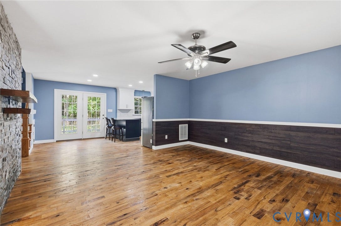 4350 Steger Creek Drive, Powhatan, VA 23139 Wood-finish flooring, stone accent wall, ceiling fan with light fixture, built-in shelving, and French doors