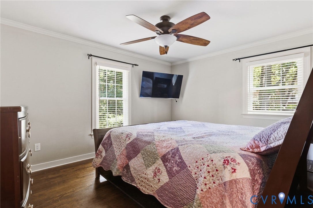 2137 Scarlet Mill Lane, Powhatan, VA 23139 Wood-finish flooring with white baseboards, crown molding, two windows with blinds, and a ceiling fan with integrated lighting