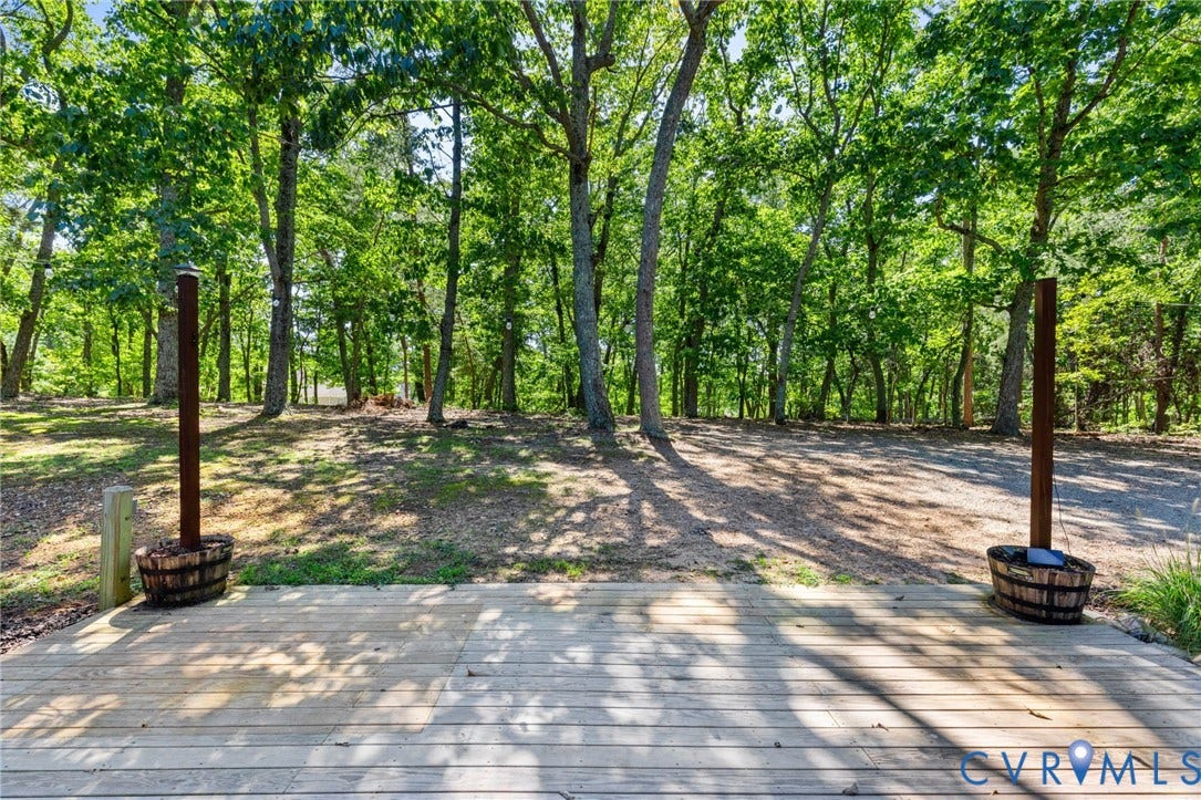 2137 Scarlet Mill Lane, Powhatan, VA 23139 Wooden deck with two outdoor showers featuring barrel bases and surrounded by mature trees
