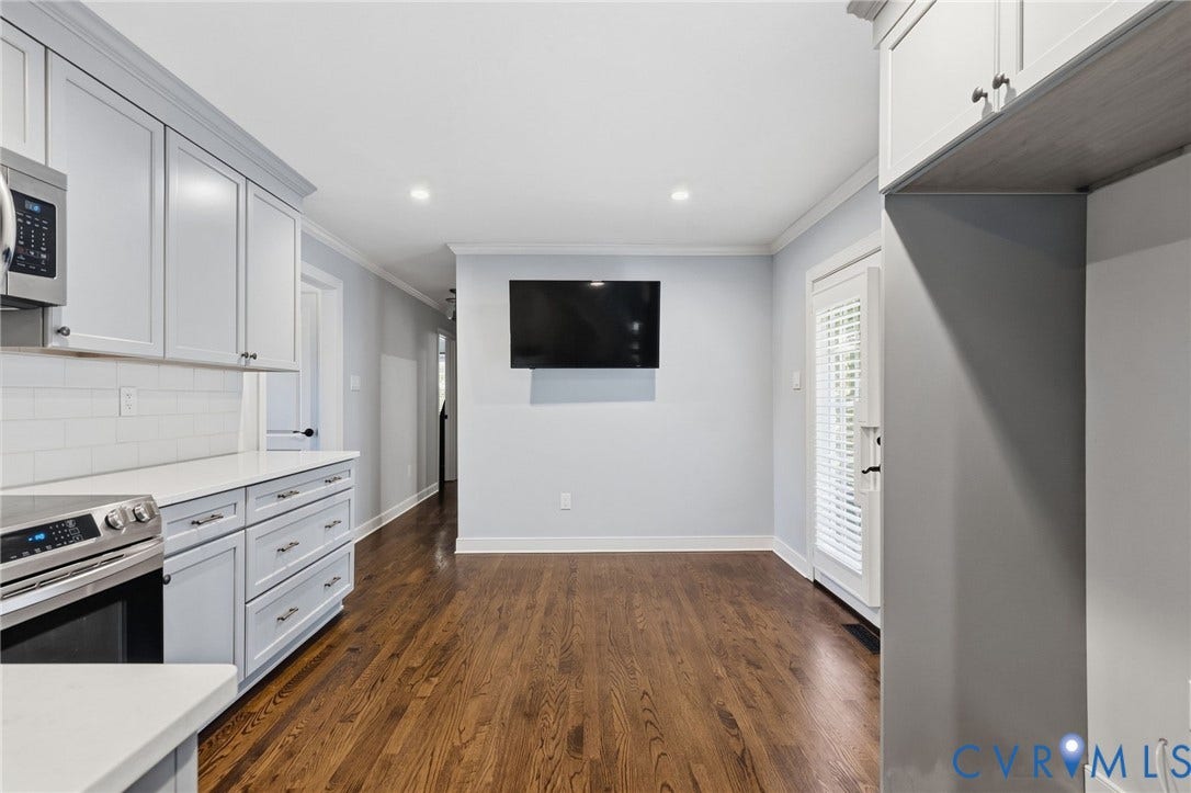 2137 Scarlet Mill Lane, Powhatan, VA 23139 Wood-finish flooring, white subway tile backsplash, stainless steel microwave, and light gray cabinetry with brushed nickel hardware