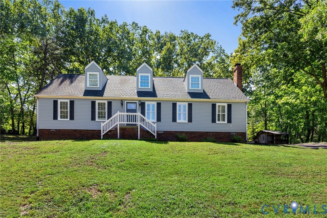 2137 Scarlet Mill Lane, Powhatan, VA 23139 Cape Cod style residence with dormer windows, a front porch with white railings, and mature trees surrounding the property
