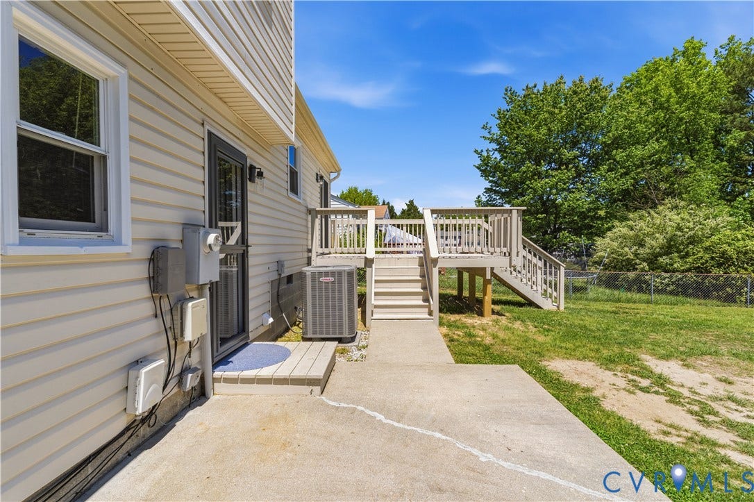 952 Pleasant Street, Henrico, VA 23223 Vinyl siding exterior with a window and exterior door, concrete patio, and a multi-level wood deck with stairs