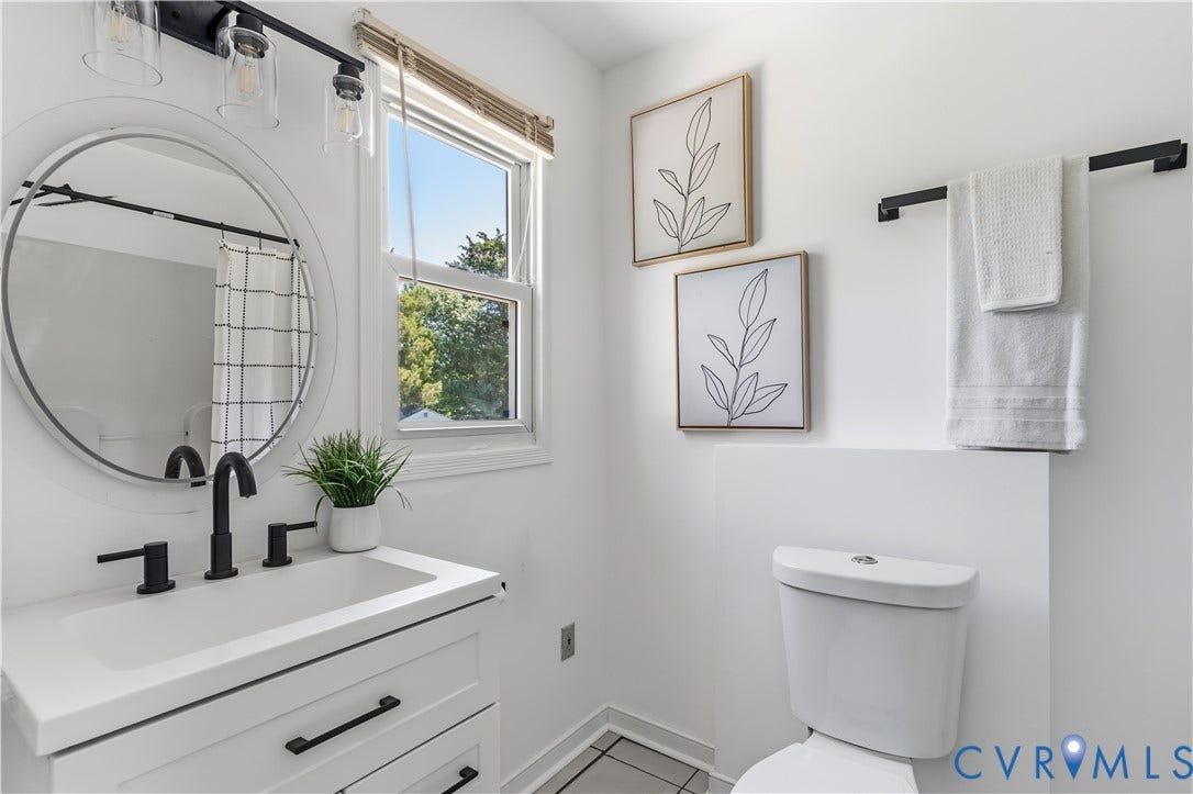 952 Pleasant Street, Henrico, VA 23223 White vanity with matte black fixtures, round mirror, and tile flooring