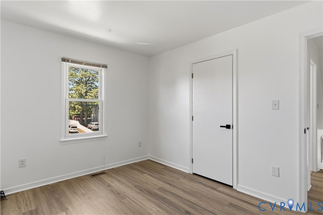 952 Pleasant Street, Henrico, VA 23223 Light wood-finish flooring, white walls, and a white interior door with matte black hardware