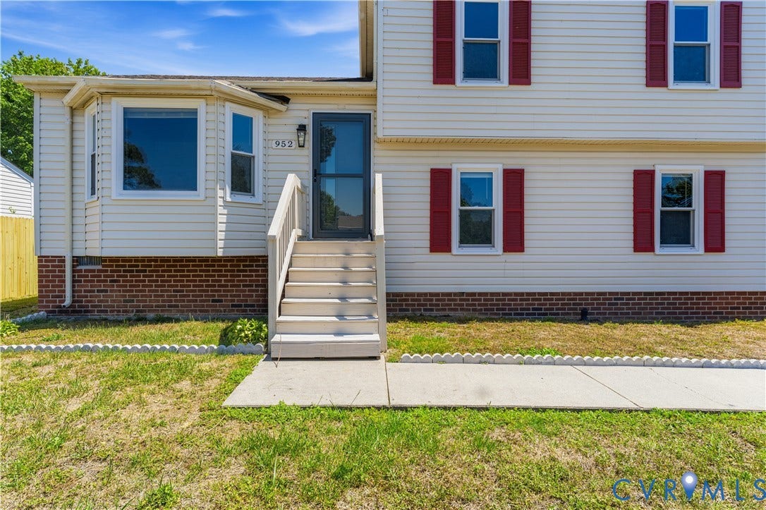 952 Pleasant Street, Henrico, VA 23223 Front exterior featuring light-colored siding, brick foundation, bay window, red window shutters, and a front entry with wood steps
