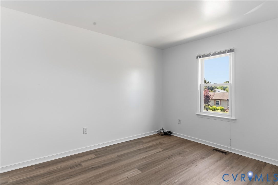 952 Pleasant Street, Henrico, VA 23223 Wood-finish flooring with white baseboards, white walls, a single window, and a ceiling-mounted light fixture