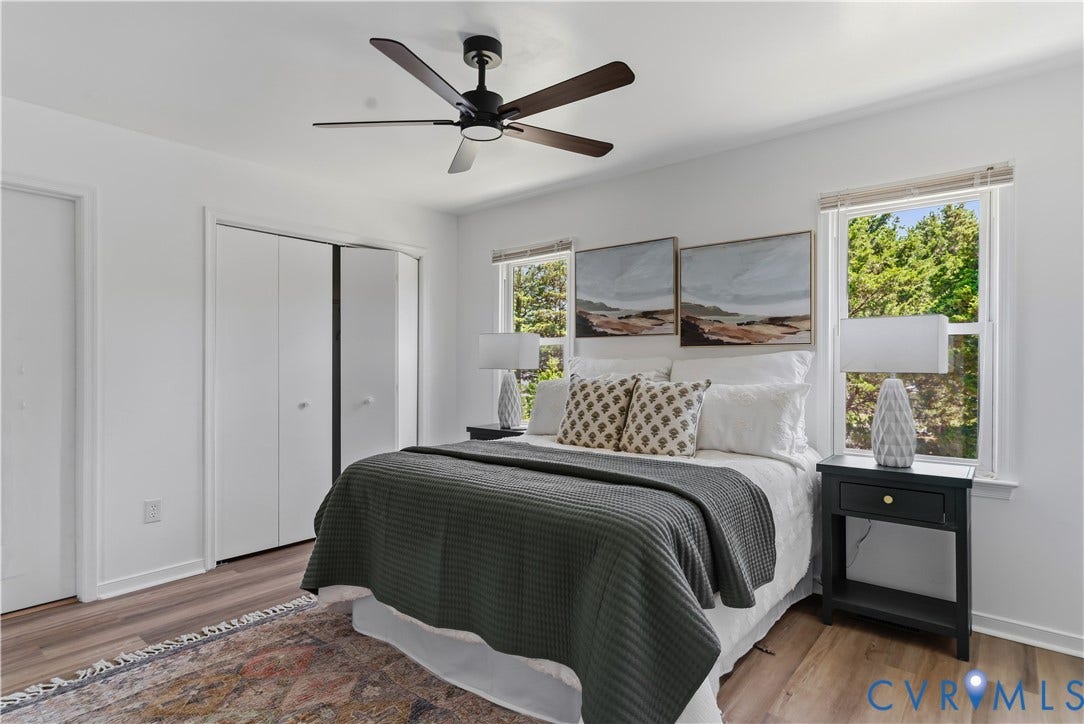 952 Pleasant Street, Henrico, VA 23223 Wood-finish flooring, white bi-fold closet doors, a dark-toned ceiling fan, and multiple windows
