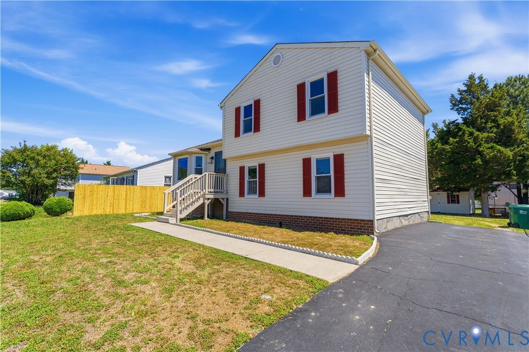 952 Pleasant Street, Henrico, VA 23223 Two-story residence featuring white siding, red window shutters, a wooden front deck with stairs, a paved driveway, and a fenced yard