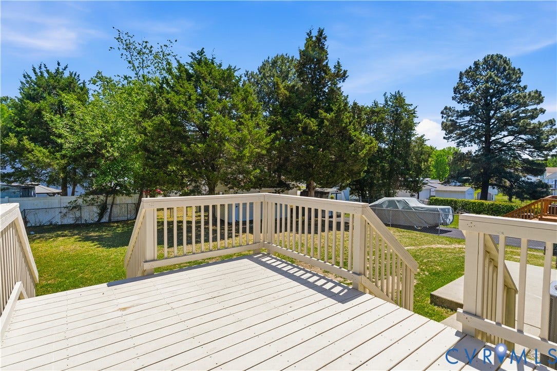 952 Pleasant Street, Henrico, VA 23223 Expansive outdoor deck with railing, featuring a large grassy yard and mature trees
