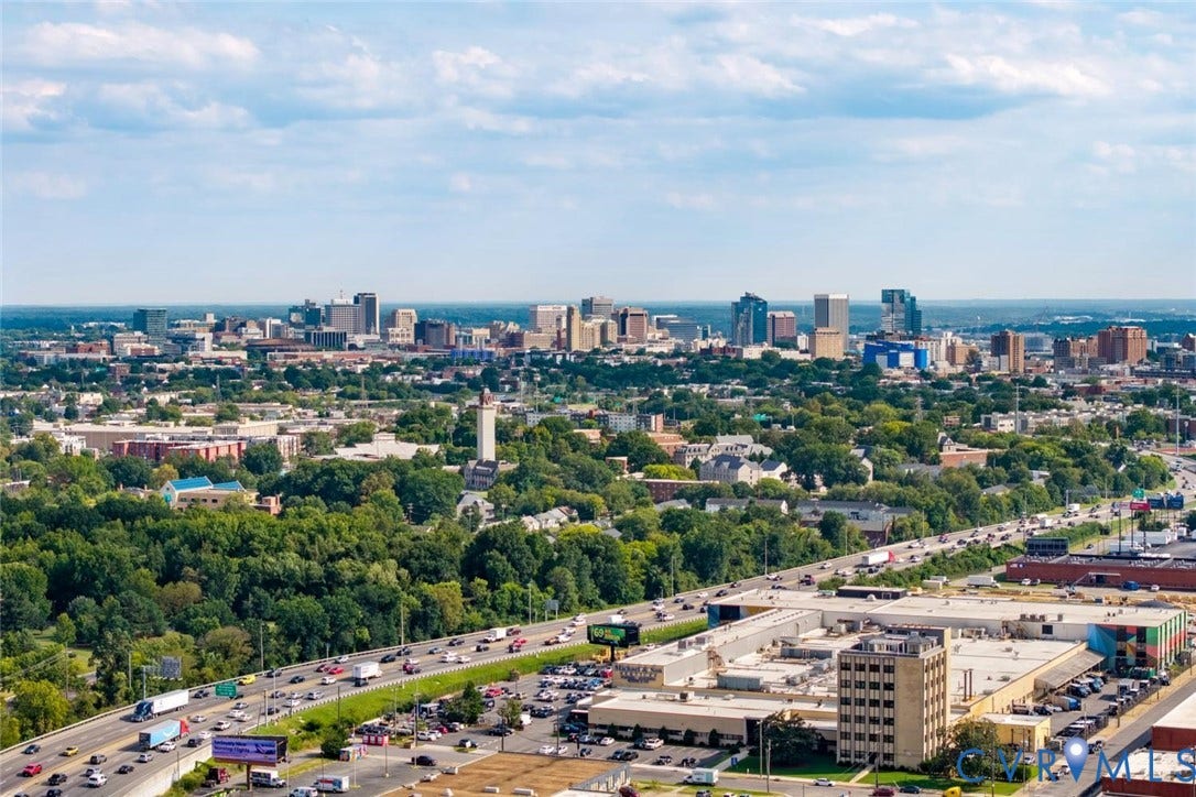 1316 Brookland Parkway, Richmond, VA 23227 Expansive aerial perspective showcasing the property's proximity to a vibrant urban skyline with downtown high-rises, tree-lined residential neighborhoods, and major thoroughfares