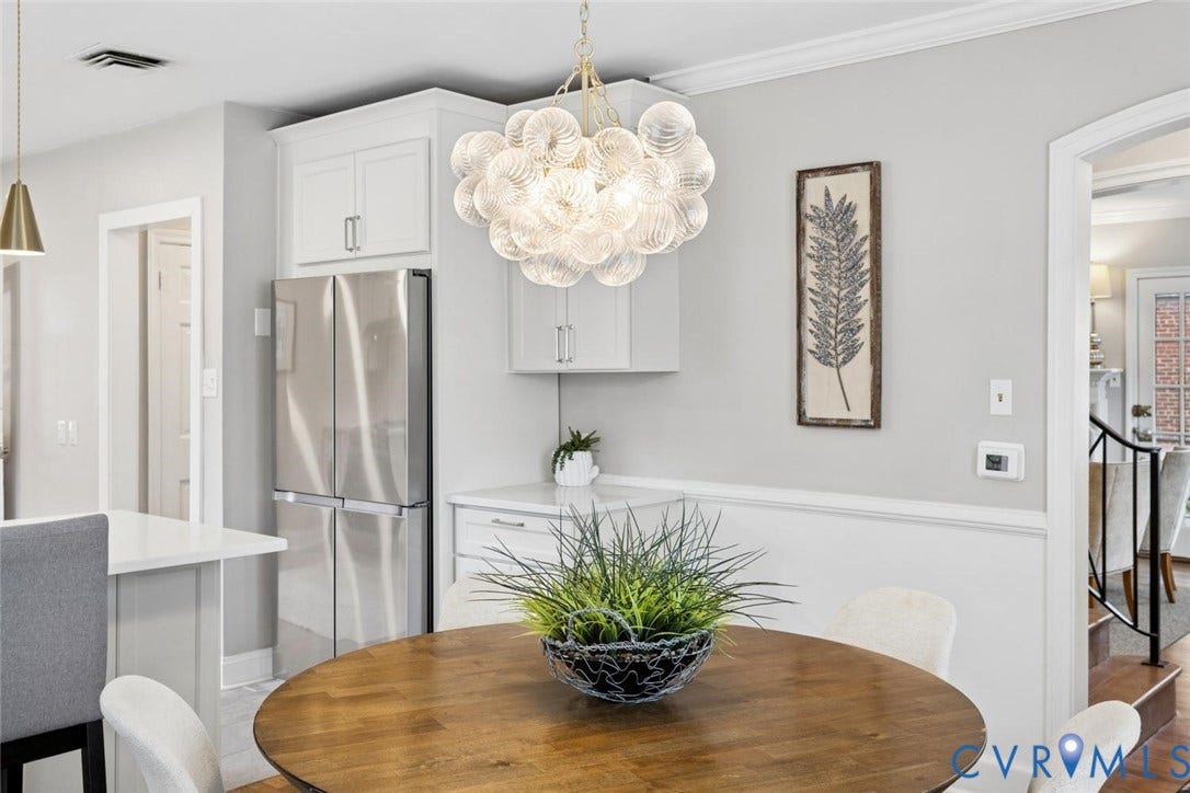 1316 Brookland Parkway, Richmond, VA 23227 Stainless steel French door refrigerator, white kitchen cabinetry, wood-finish flooring, contemporary chandelier, and arched doorway