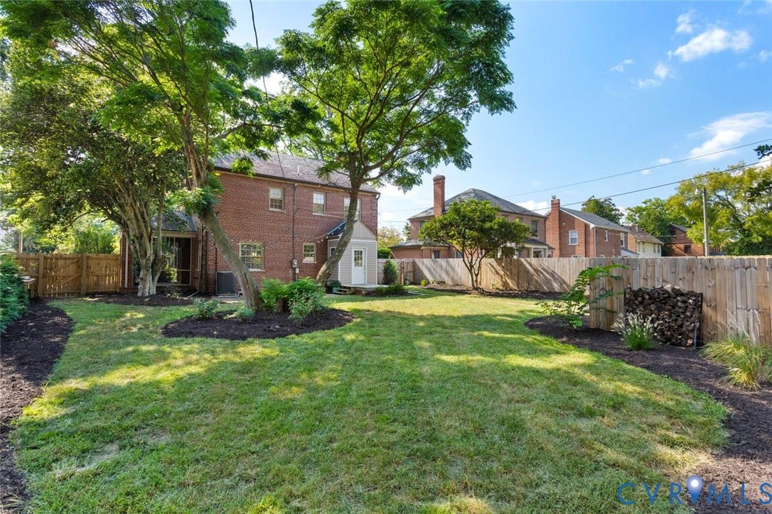 1316 Brookland Parkway, Richmond, VA 23227 Expansive backyard featuring a manicured lawn, established trees, and perimeter fencing