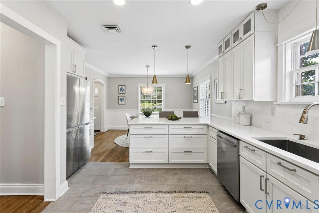 1316 Brookland Parkway, Richmond, VA 23227 White shaker-style cabinetry with chrome hardware, stainless steel appliances, a center island with seating, a deep undermount sink, and light-toned flooring