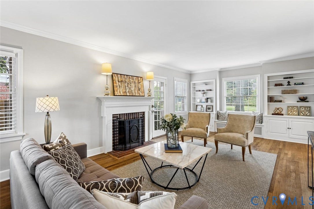 1316 Brookland Parkway, Richmond, VA 23227 Hardwood flooring, crown molding, built-in shelving, a brick fireplace with a white mantel, and white plantation shutters