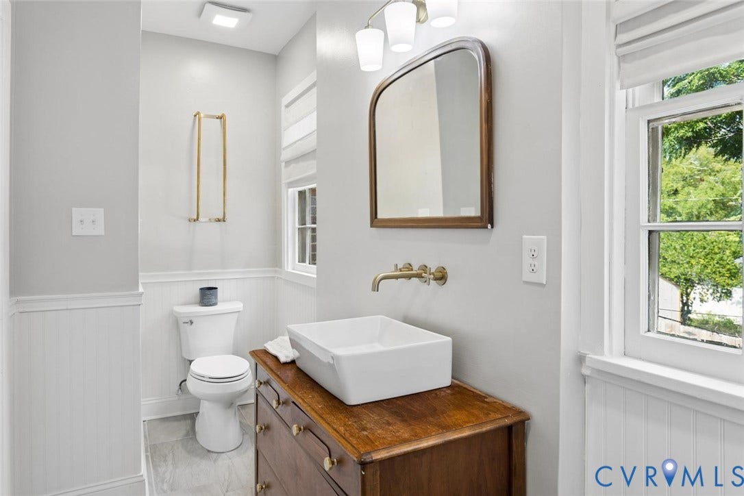 1316 Brookland Parkway, Richmond, VA 23227 Bathroom with wainscoting, wood-finish vanity, vessel sink, wall-mounted brass-finish faucet, and a large mirror