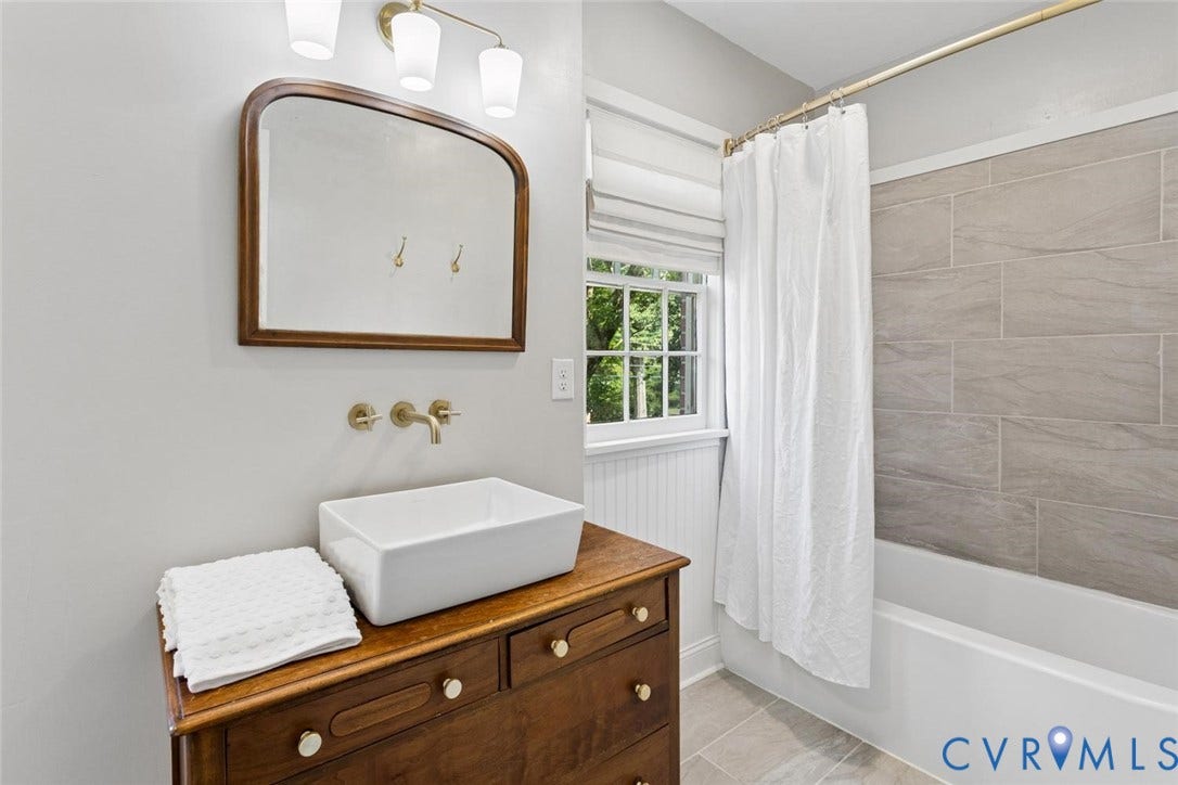 1316 Brookland Parkway, Richmond, VA 23227 Rectangular vessel sink with wall-mounted brass faucet, wood vanity, and framed mirror