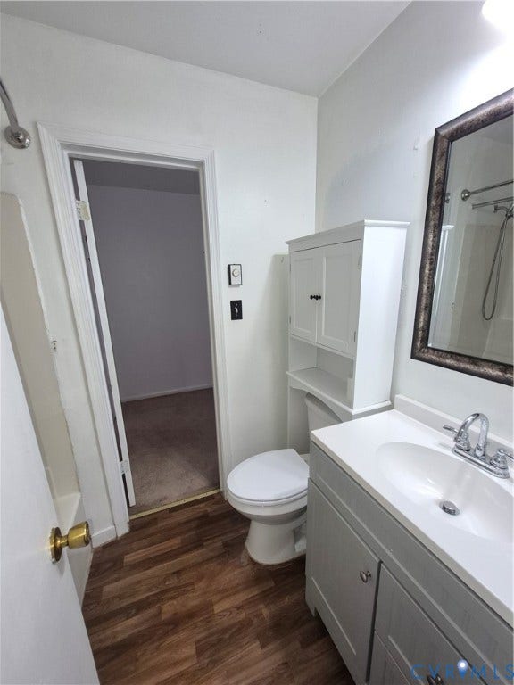 9324 Shiloh Drive, Chesterfield, VA 23237 Wood-finish flooring, white vanity with integrated sink, white built-in storage cabinet, and a framed mirror