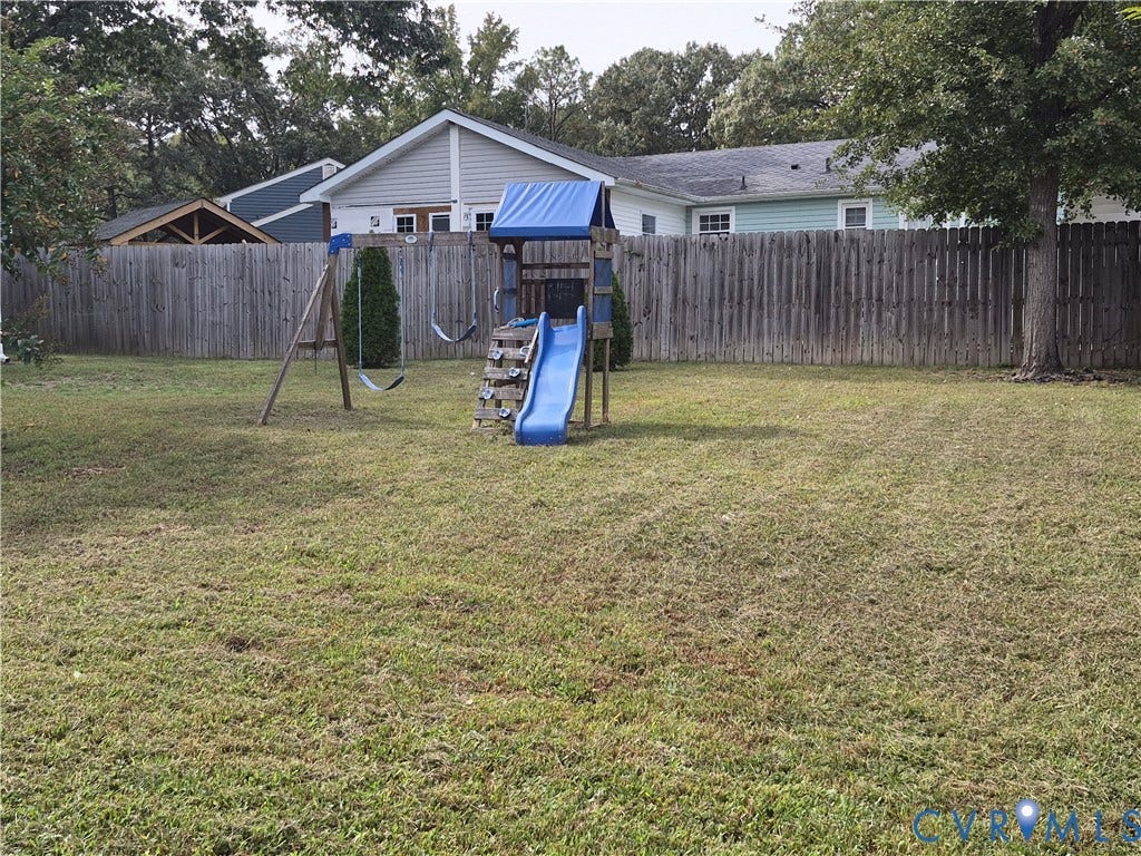 9324 Shiloh Drive, Chesterfield, VA 23237 Expansive grassed yard featuring a wooden privacy fence and mature trees