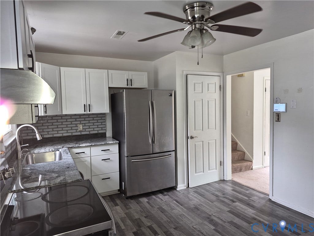 9324 Shiloh Drive, Chesterfield, VA 23237 Kitchen featuring wood-finish flooring, white cabinetry with dark hardware, a stainless steel refrigerator, and dark countertops