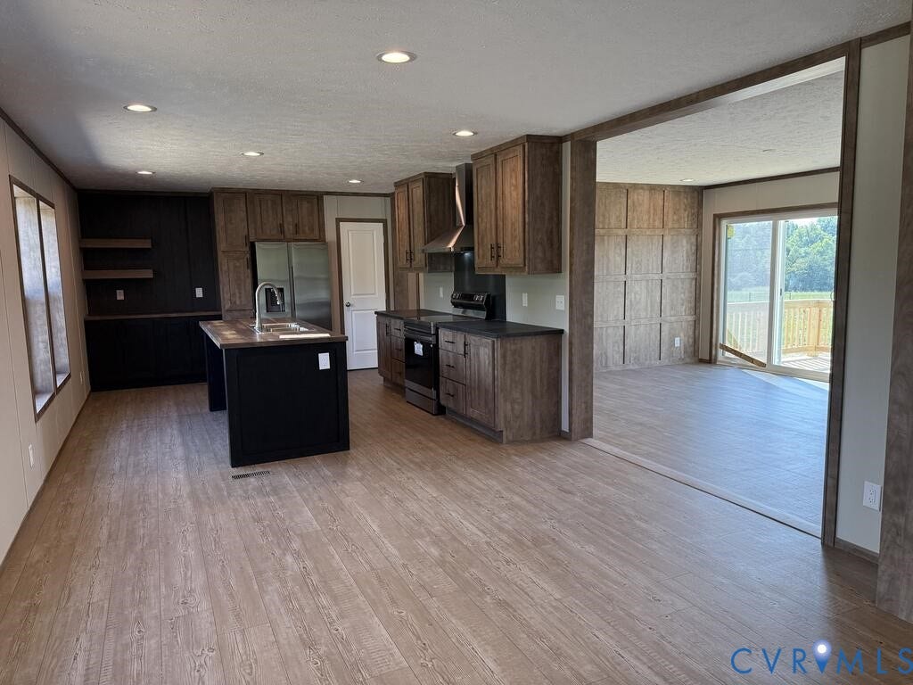 3035 Cumberland Road, Cumberland, VA 23040 Expansive kitchen and dining area featuring wood-finish flooring, recessed lighting, a central island with sink, dark cabinetry, and stainless steel appliances