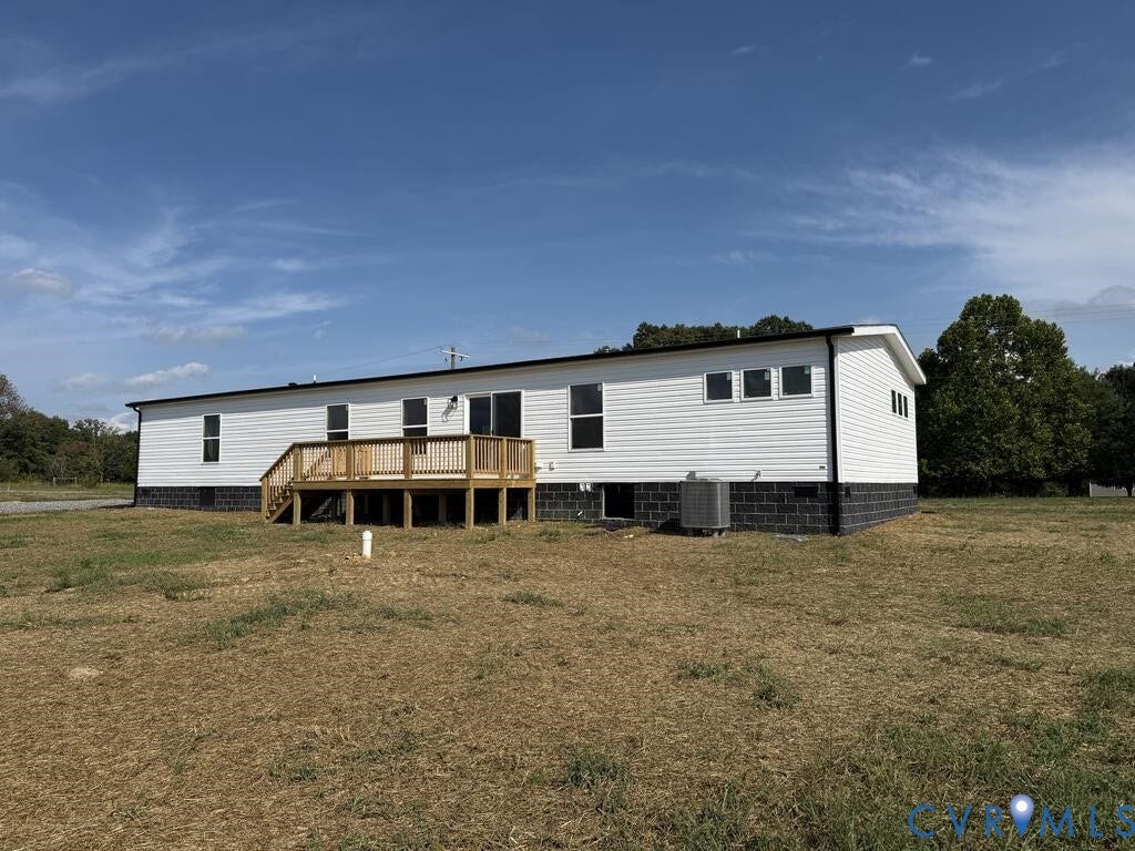 3035 Cumberland Road, Cumberland, VA 23040 Rear exterior featuring white horizontal siding, black trim, a wood deck, black block foundation, and multiple windows