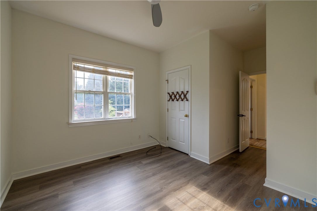 Wood-finish flooring, white trim, and a ceiling fan