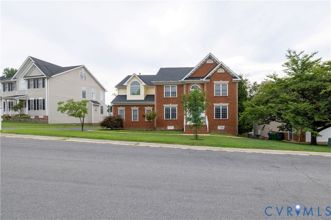 Brick exterior with gabled roofline, arched window, and prominent white trim details