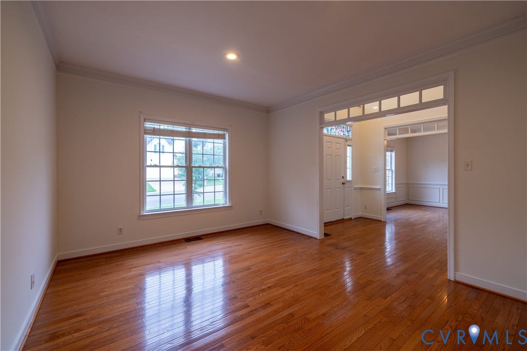 Hardwood flooring, crown molding, recessed lighting, grid-pattern window, and transom window above doorway